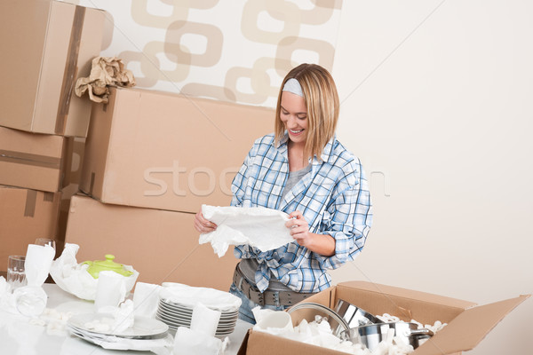 Moving house: Happy woman unpacking dishes Stock photo © CandyboxPhoto