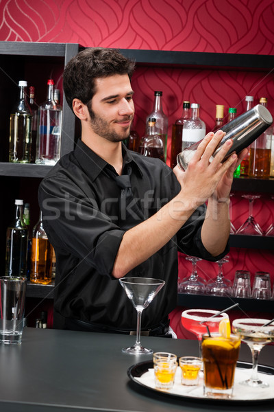 Stock photo: Young bartender make cocktail shaking drinks