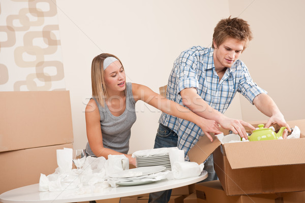 Moving house: Young couple unpacking kitchen dishes Stock photo © CandyboxPhoto