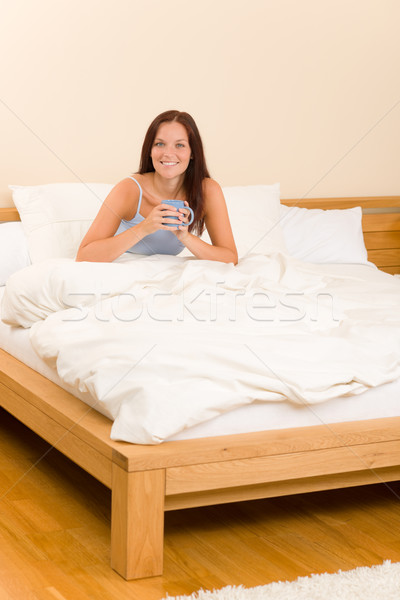 Stock photo: Bedroom - young woman drink coffee in bed