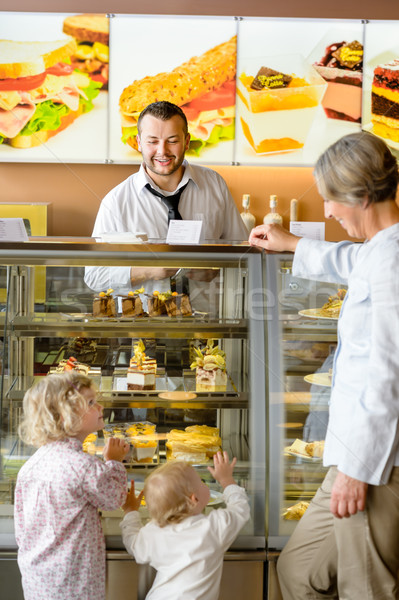 Stock photo: Grandchildren asking grandmother for cakes at cafe