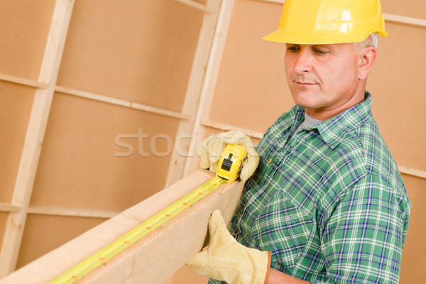 Stock photo: Handyman mature carpenter measure wooden beam