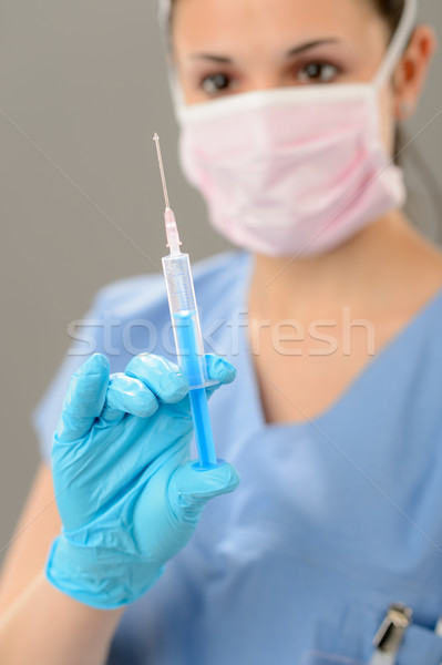 Female nurse with syringe in face mask Stock photo © CandyboxPhoto