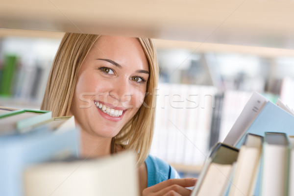 Student biblioteki wesoły kobieta wygląd półka na książki Zdjęcia stock © CandyboxPhoto