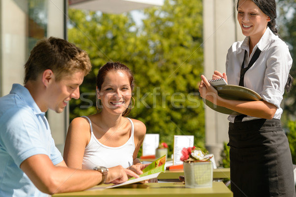 Stock photo: Couple at cafe ordering from menu waitress