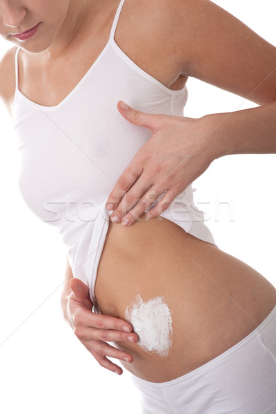 Stock photo: Body care series - Woman applying cream on  her belly