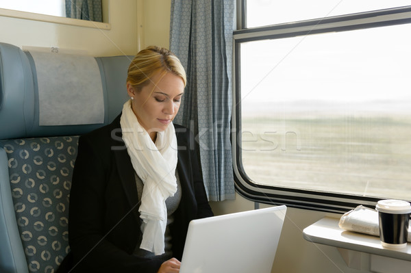 [[stock_photo]]: Femme · utilisant · un · ordinateur · portable · train · banlieue · sérieux