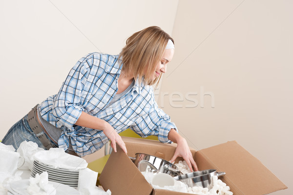 Moving house: Happy woman unpacking dishes Stock photo © CandyboxPhoto