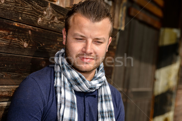 Pensive attractive man leaning against wooden wall Stock photo © CandyboxPhoto