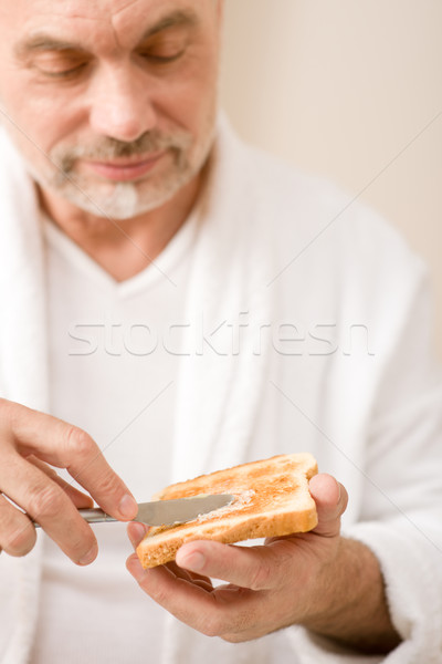 Imagine de stoc: Senior · om · matur · mic · dejun · pâine · prăjită · unt · purta