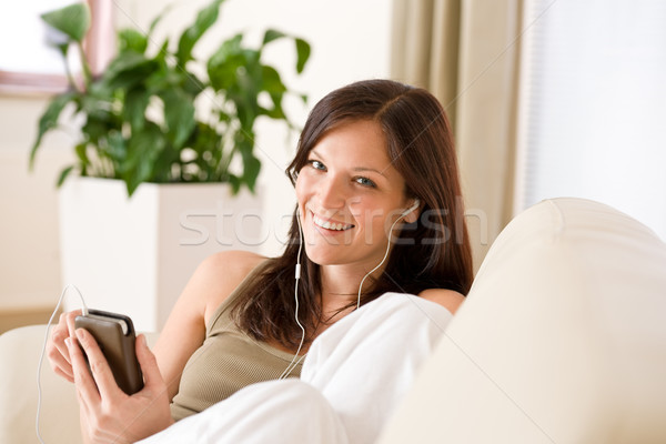 Woman holding music player listening in lounge Stock photo © CandyboxPhoto