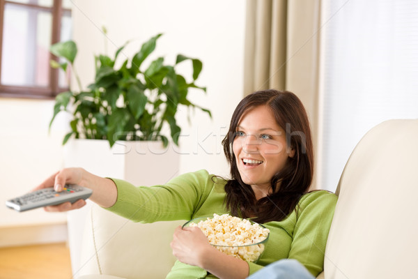 Stock photo: Woman watching television with popcorn in living room