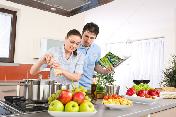 [[stock_photo]]: Jeunes · heureux · couple · Cook · cuisine · livre · de · cuisine
