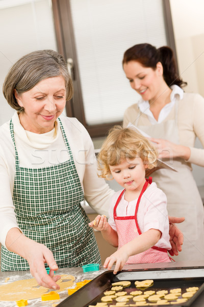 Little girl with grandmother cutting out cookies Stock photo © CandyboxPhoto