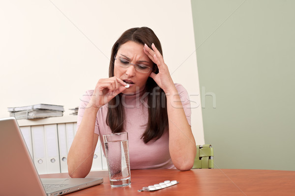 Stock photo: Businesswoman with headache take pill