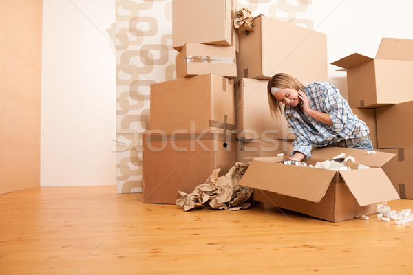 Moving house: Happy woman unpacking box Stock photo © CandyboxPhoto