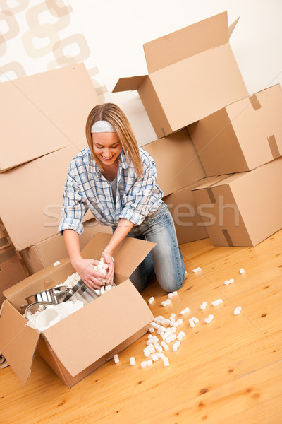 Moving house: Happy woman unpacking box Stock photo © CandyboxPhoto