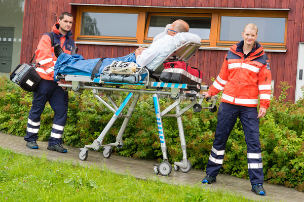 Stock photo: Paramedics with patient on stretcher ambulance aid