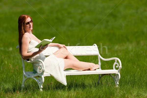 Stock photo: Red hair woman reading book on white bench in spring