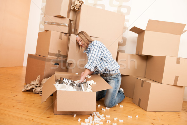 Moving house: Happy woman unpacking box Stock photo © CandyboxPhoto