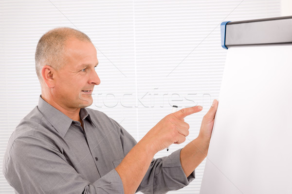 Mature businessman writing at empty flip chart Stock photo © CandyboxPhoto