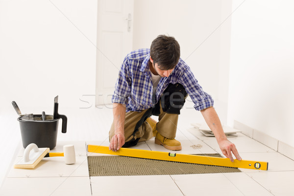 Stock photo: Home tile improvement - handyman with level