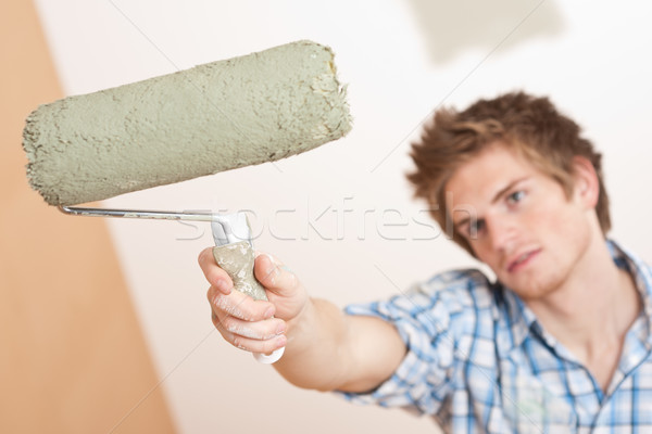 Home improvement: Young man holding paint roller Stock photo © CandyboxPhoto