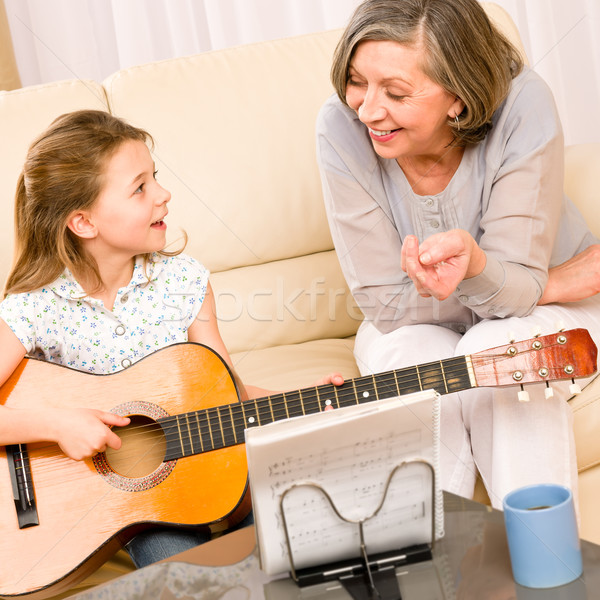 Stock photo: Young girl sing play guitar to grandmother