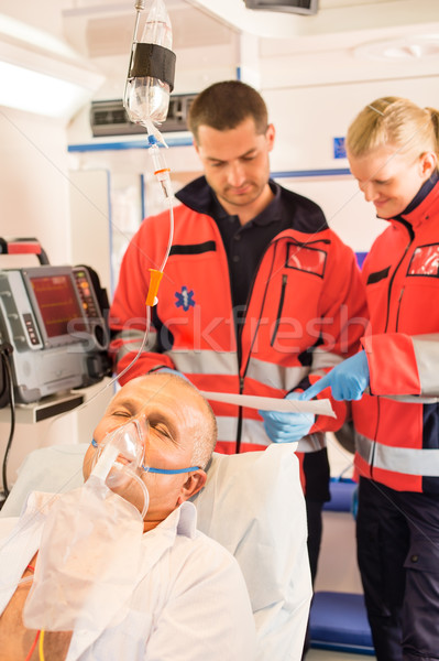 Paramedics reading EKG in ambulance patient help Stock photo © CandyboxPhoto