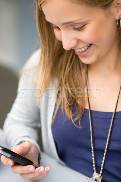 Smiling woman reading text message on cellphone Stock photo © CandyboxPhoto