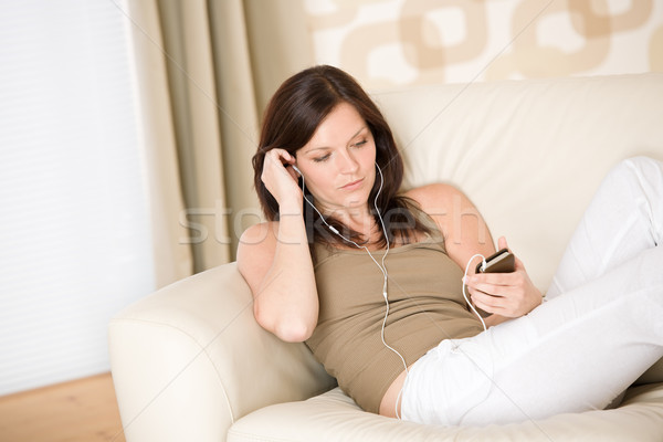 Woman holding music player listening on sofa home Stock photo © CandyboxPhoto