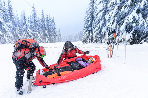 Stock photo: Ski patrol with rescue sled injured woman