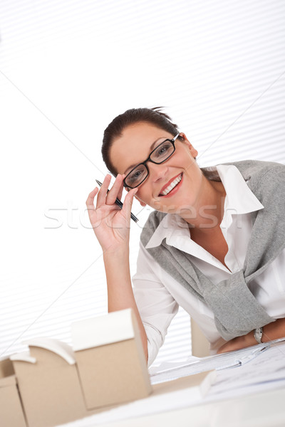 Stock photo: Young female architect writing with pen 