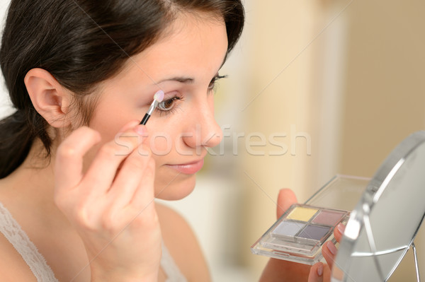Young girl applying eyeshadow looking at mirror Stock photo © CandyboxPhoto