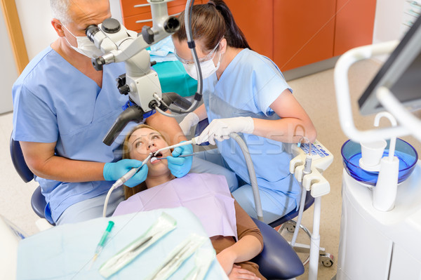 Dentist operating patient through microscope  Stock photo © CandyboxPhoto