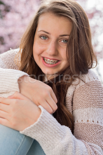 Girl with braces hugging knees in nature Stock photo © CandyboxPhoto