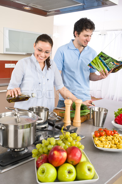 [[stock_photo]]: Jeunes · heureux · couple · Cook · cuisine · livre · de · cuisine