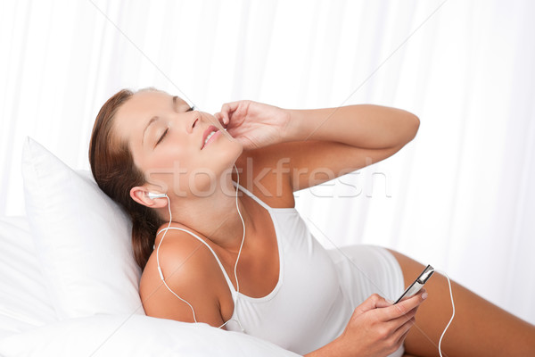 Fiatal nő tart mp3 lejátszó fül fehér nő Stock fotó © CandyboxPhoto