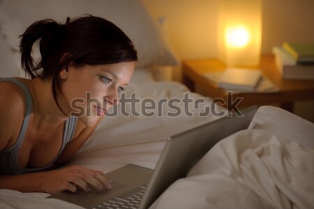 Yatak odası akşam kadın dizüstü bilgisayar yatak Stok fotoğraf © CandyboxPhoto