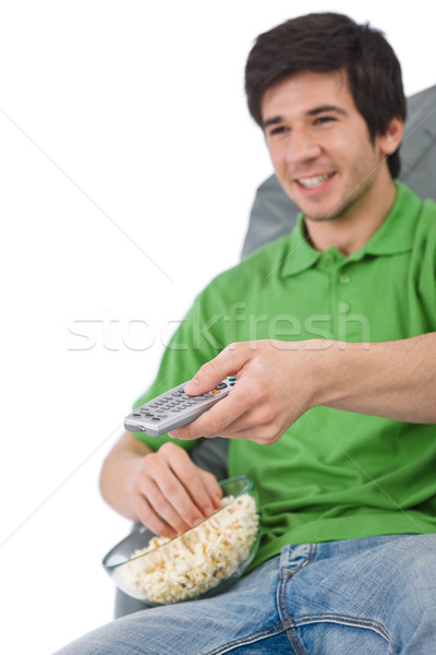 Young man holding remote control watch television Stock photo © CandyboxPhoto