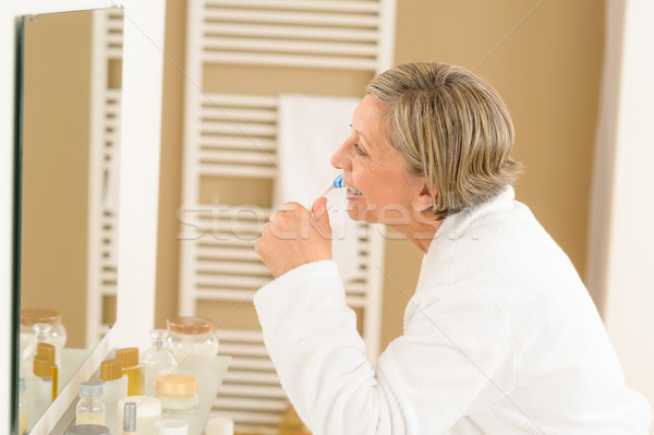 Idős nő fogmosás fürdőszoba tükör üveg Stock fotó © CandyboxPhoto