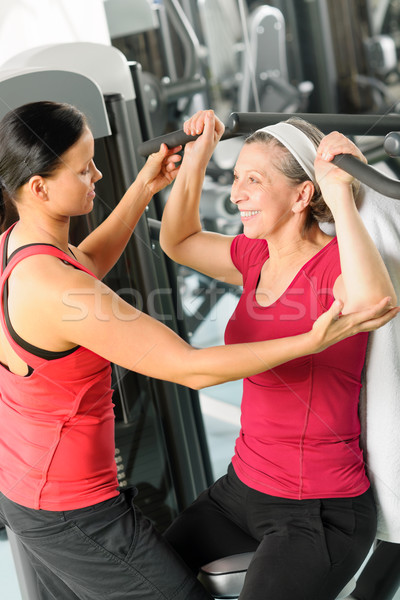 Stock photo: Personal trainer assist senior woman at gym