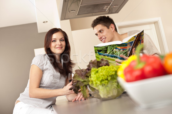 Young couple in kitchen choosing recipe from cookbook Stock photo © CandyboxPhoto