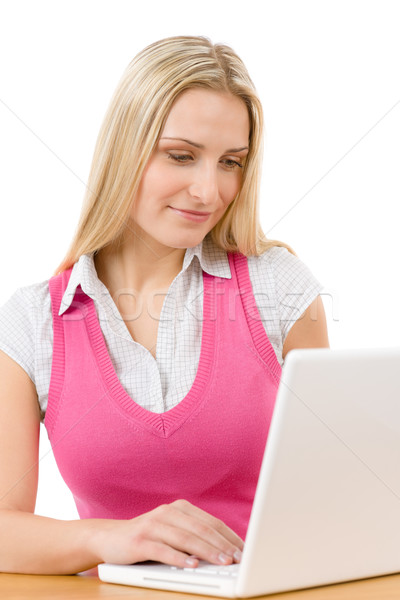 Stock photo: Happy teenager woman sitting at table with laptop