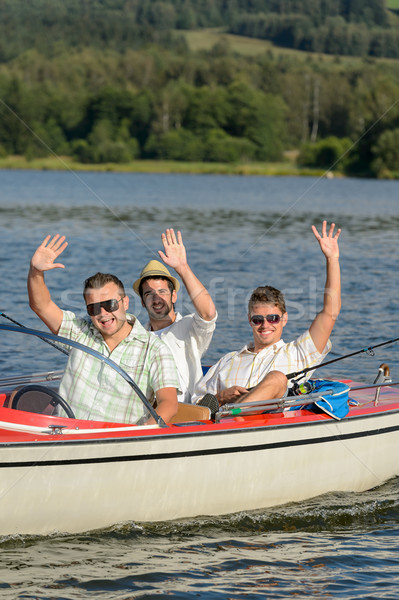 Cheerful young men sitting in motorboat Stock photo © CandyboxPhoto