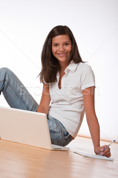 Smiling teenager sitting with laptop and writing notes  Stock photo © CandyboxPhoto