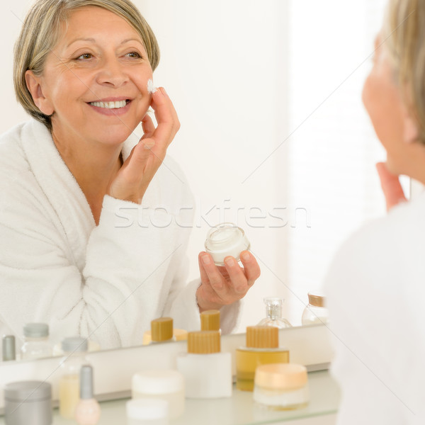 Idős nő krém néz tükör mosolyog Stock fotó © CandyboxPhoto