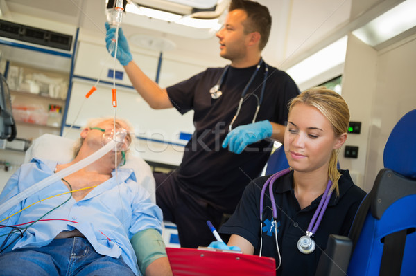 Paramedical team treating man in ambulance car Stock photo © CandyboxPhoto