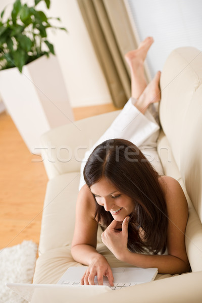 Stock photo: Young woman with laptop on sofa home in living room