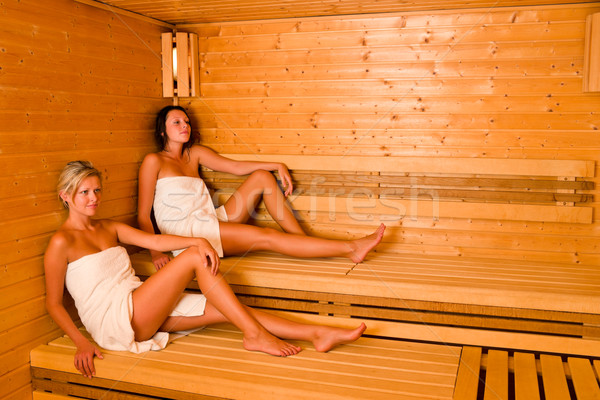 Stock photo: Sauna two women relaxing sitting wrapped towel
